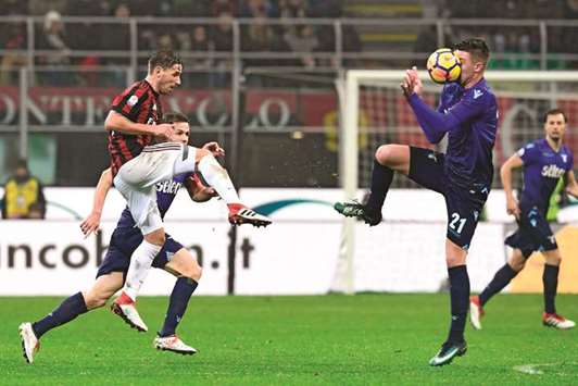Laziou2019s Sergej Milinkovic-Savic (right) is hit by a ball shot from AC Milanu2019s Lucas Biglia (L) during the Italian Cup match in Milan. (AFP)