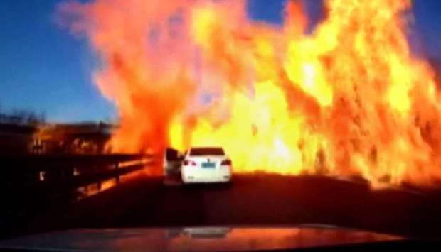 The door of a car (C) opening as a wall of flames ignites a long strip of motorway along the Beijing-Harbin Expressway in Hebei province, bordering Beijing. screengrab taken from dash cam video yesterday and released to AFPTV from CCTV.