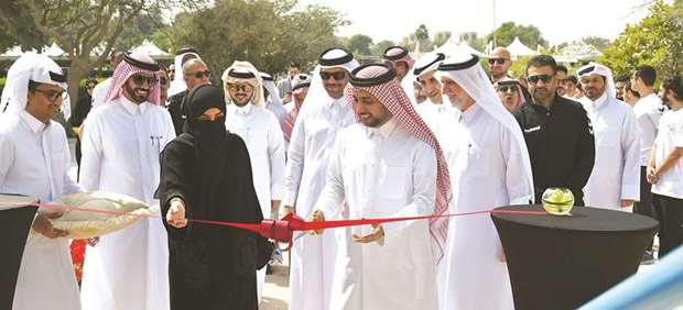 QU president Dr Hassan al-Derham cutting a ribbon to inaugurate the new gym as other officials look on.
