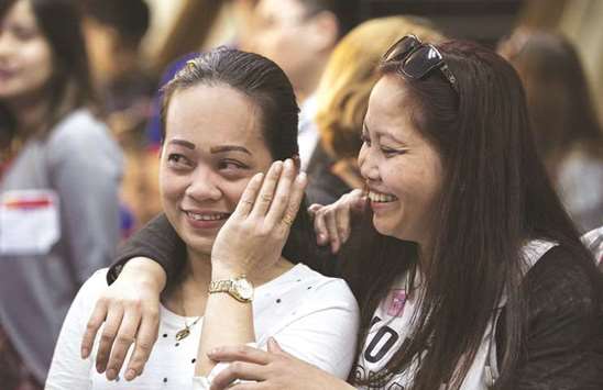 Overseas Filipina workers (OFW) react after arriving in Manila from Kuwait at Manila International Airport yesterday.