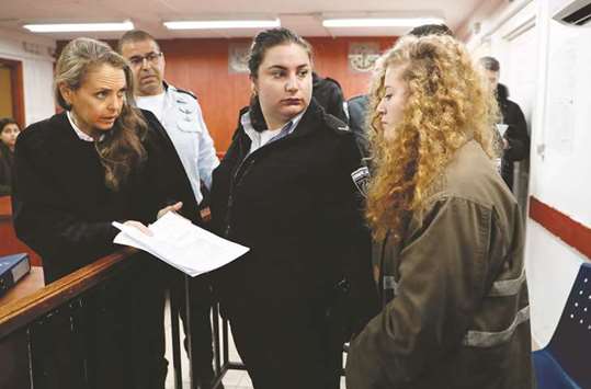 Sixteen-year-old Palestinian Ahed Tamimi (right), a well-known campaigner against Israelu2019s occupation, arrives for the beginning of her trial in the Israeli military court at Ofer military prison in the West Bank village of Betunia yesterday.