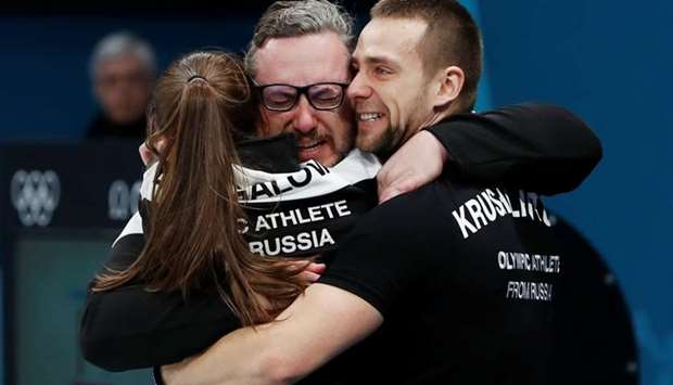 Aleksandr Krushelnitckii and Anastasia Bryzgalova, Olympic athletes from Russia, hug their coach Vasily Gudin after winning the bronze