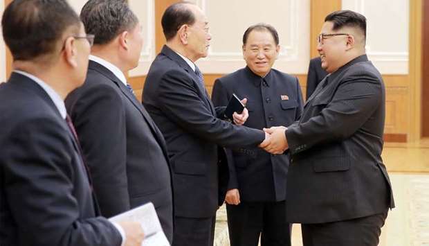 North Korean leader Kim Jong-Un (R) greeting members of the high-level delegation that visited south Korea to attend the opening ceremony of the Winter Olympics on Monday.