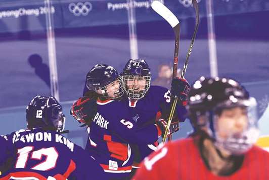 Unified Koreau2019s Randi Griffin (second from right) celebrates her goal with teammate Caroline Nancy Park (second from left) during the womenu2019s preliminary round ice hockey match against Japan in Gangneung, South Korea, yesterday. (AFP)