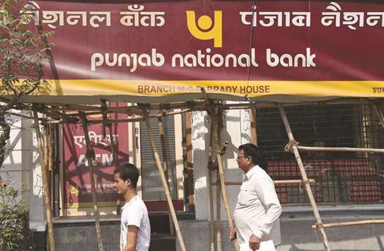 Men walk past the Punjab National Banku2019s Brady House Branch in south Mumbai yesterday where a fraud of almost $1.8bn was detected.