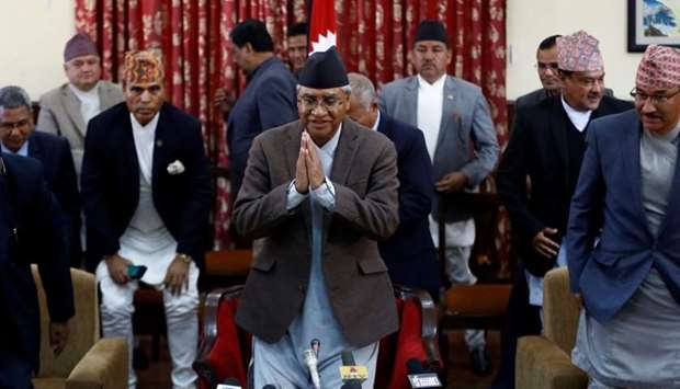 Nepalese Prime Minister Sher Bahadur Deuba greets as he leaves after announcing his resignation in Kathmandu