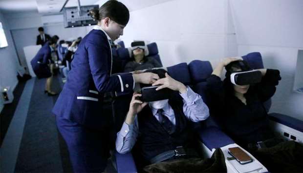 Staff dressed as flight attendants, help guests to wear VR goggles at the ,First Airlines,, virtual first-class airline experience facility in Tokyo