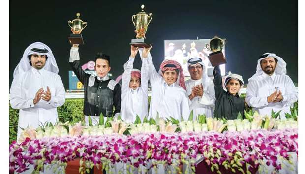 Qatar Racing and Equestrian Club (QREC) deputy chief steward Abdullah al-Kubaisi (third from right) and Saad al-Hajri (right), head of Grandstand and Protocol, with the winners of the Al Khor Cup after Hassan al-Matwiu2019s Raqee won the six-furlong dirt feature at the QREC yesterday. PICTURE: Juhaim