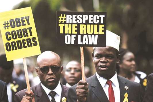 Kenyan lawyers hold placards with yellow ribbons during a demonstration against impunity and disobedience of court orders by the government, in Nairobi, yesterday.