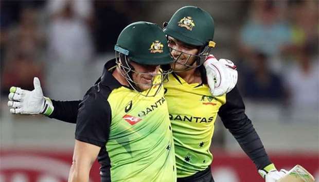 Australia's Alex Carey (right) and Aaron Finch celebrate the win during the Twenty20 tri-series against New Zealand at Eden Park in Auckland on Friday.