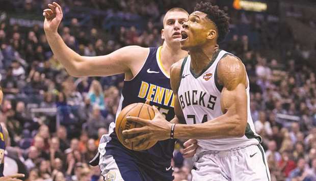 Milwaukee Bucksu2019 Giannis Antetokounmpo (right) drives for a shot around Denver Nuggetsu2019 Nikola Jokic during the fourth quarter of the NBA game on Thursday. (USA TODAY Sports)