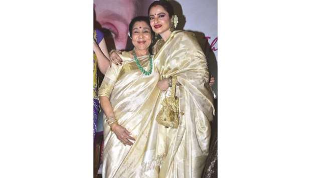 Veteran actress Rekha hugs Bollywood playback singer Asha Bhosale at the Yash Chopra Memorial Award in Mumbai.