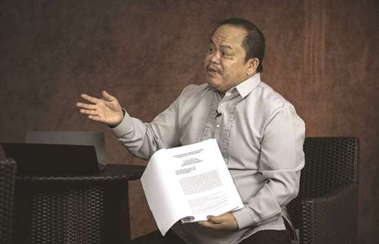 Lawyer Jude Sabio gestures as he shows the communication he submitted to the International Criminal Court against President Rodrigo Duterte, during an interview in Manila.