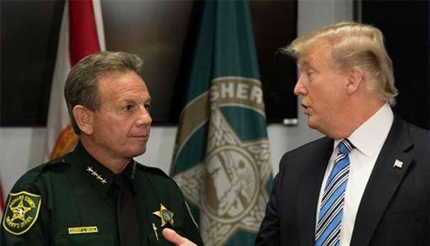 US President Donald Trump speaks with Broward County Sheriff Scott Israel while visiting first responders at Broward County Sheriff's Office in Pompano Beach, Florida, after a mass shooting that claimed 17 lives at a nearby high school.