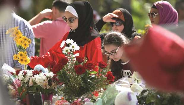 People bring flowers to a temporary memorial at Pine Trails Park in Parkland, Florida.