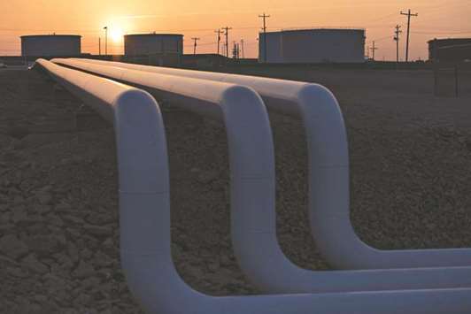 The sun rises beyond oil storage tanks at the Enbridge Cushing storage terminal in Oklahoma (file). An enticing market for US crude exports, new pipelines increasing shipping options, and elevated refining demand have contributed to dwindling stockpiles at Cushing.