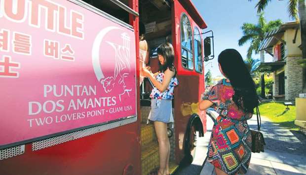 Tourists board on a shuttle bus near the tourist resorts in Tamuning on the island of Guam in this file picture.