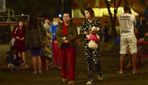 Residents stand out in the street following a 5.9 magnitude quake in Mexico City early Monday.