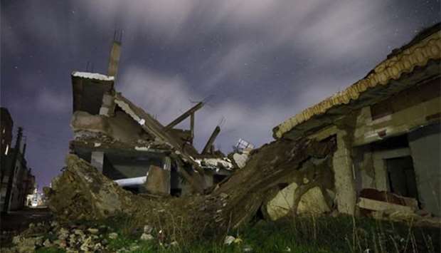 Damaged houses are pictured at night in the rebel-held area of Daraa, Syria.
