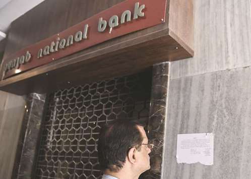 A man reads a notice by the Indian Central Bureau of Investigation (CBI) stating that the Brady House branch of the Punjab National Bank (PNB) has been sealed next to the entrance of the branch in Mumbai yesterday.