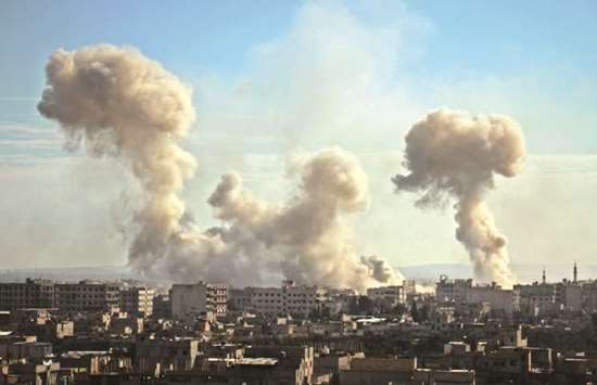 Smoke rises from buildings following bombardment on the village of Mesraba in the rebel-held besieged Eastern Ghouta region on the outskirts of the capital Damascus, yesterday.