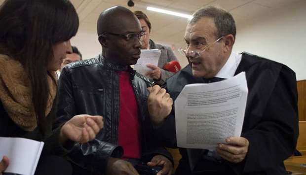 Ali Ouattara, 45 (C) talk with his lawyer Juan Isidro Fernandez (R) in court during his trial in Ceuta, a Spanish overseas territory in northern Morocco