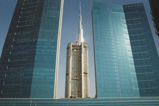A tower under construction (centre) is seen beyond the Sofitel hotel and the Burj Khalifa skyscraper in Dubai. Real estate prices in Dubai could decline by 10% to 15% over the next two years, hit by new supply, geopolitical risks and the introduction of value added-tax in the United Arab Emirates, S&P Global Ratingsu2019 analysts said yesterday.
