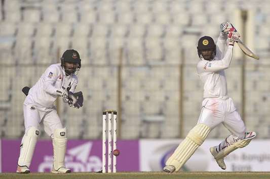 Sri Lanka cricketer Dhananjaya de Silva (R) plays a shot as the Bangladesh wicket-keeper Liton Das (L) looks on during the second day of the first Test match at Zahur Ahmed Chowdhury Stadium in Chittagong yesterday.
