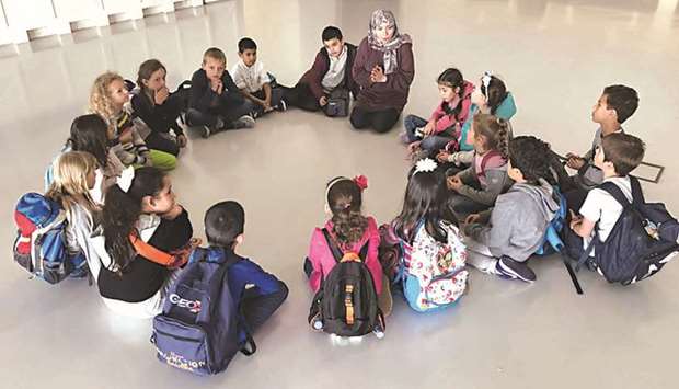 A Mathaf educator leads an interactive, theme-based lesson with a group of students.