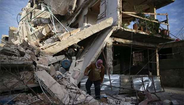 A man inspects a damaged building in the besieged town of Douma, Eastern Ghouta.
