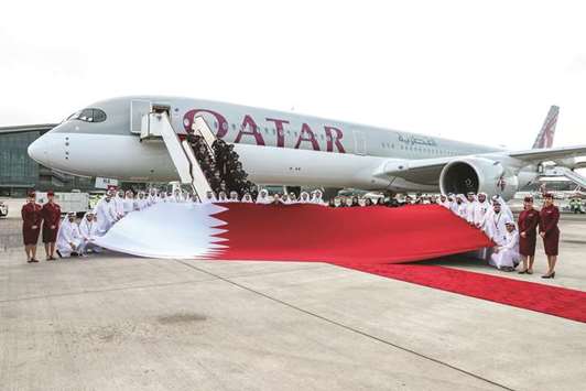 Group chief executive Akbar al-Baker and national employees of Qatar Airways Group with the Qatari flag in front of the Airbus A350-1000, the airlineu2019s and the worldu2019s first such commercial aircraft. PICTURES: Nasar T K