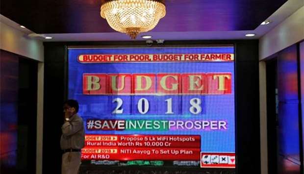 A man speaks on his mobile phone next to a screen telecasting India's budget, inside the Bombay Stock Exchange building in Mumbai on Thursday.