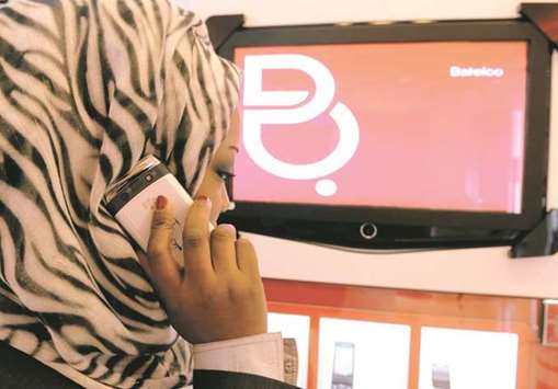 An employee poses with a handset in a Bahrain Telecommunications Co store at Seef Mall, in Seef, Bahrain (file). Batelcou2019s full-year 2017 consolidated net profit was 3.5mn dinars, 91% down from the year earlier period.