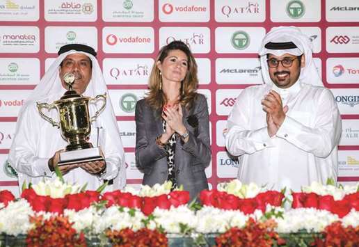 Al Shahania Stud director Abdul Rahman al-Mansour (left) receives the owneru2019s trophy from Qatar Racing and Equestrian Club (QREC) general manager Nasser Sherida al-Kaabi (right) after Reda won the Al Zubara Trophy. PICTURE: Juhaim