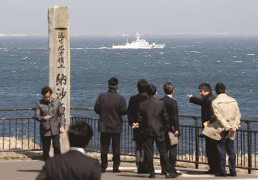 In this file picture, Japan Coast Guard vessel PS08 Kariba sails off Cape Nosappu, easternmost point in Japan, in Nemuro on Hokkaido island, as part of a group of islands known as the Northern Territories in Japan and the Southern Kuriles in Russia can be seen in the background.