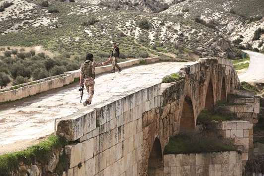 Turkish-backed Syrian opposition fighters walk on the Roman bridge in the archaeological site of Cyrrhus, or Nabi Huri, northeast of the Syrian city of Afrin, yesterday.