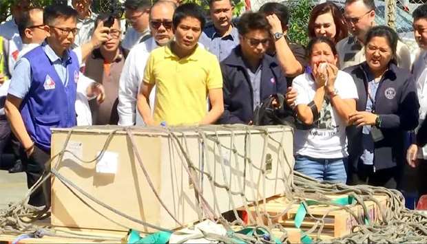 Jessica (second right), sister of Filipina overseas worker Joanna Demafelis, cries in front of a wooden casket containing her sisteru2019s body after it arrived in Manila earlier this year.