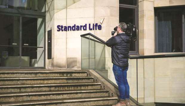 A television cameraman films outside the Standard Life head office in Edinburgh. SLA will receive u00a32.3bn in cash and a 19.9% stake in Phoenix, which is raising u00a31bn to fund the deal to become Europeu2019s largest manager of books of mature business from insurance companies.