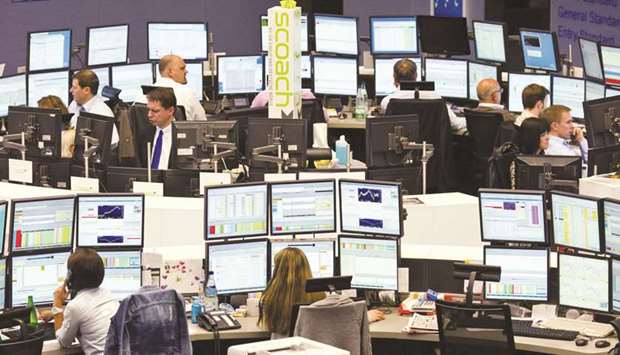 Brokers work at the stock exchange in Frankfurt. The DAX 30 ended 0.2% up at 12,483.79 points yesterday.