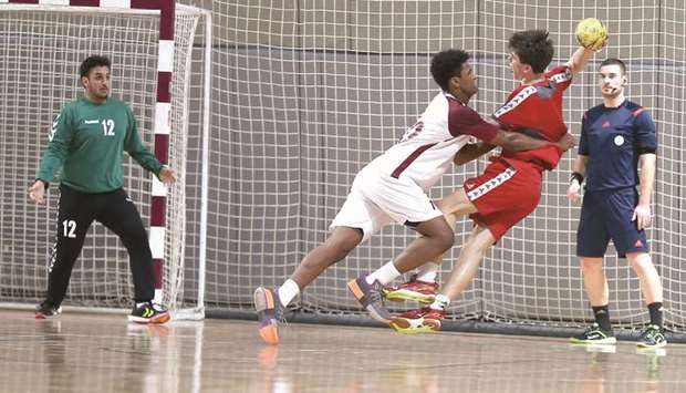 A Qatar defender attempts to stop a Austrian player from scoring during the ISF World Schools Handball Championships at the Ali Bin Hamed Al Attiyah Arena yesterday.