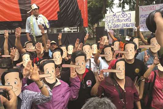 Pro-democracy activists wearing masks mock Thailandu2019s Prime Minister Prayuth Chan-ocha as Pinocchio during a protest against junta at a university in Bangkok, yesterday.