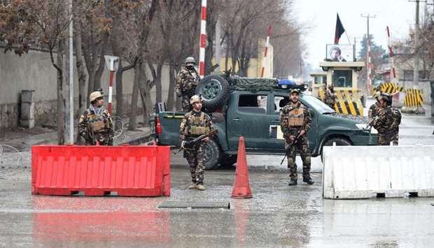Afghan security personnel stand guard near the site of a suicide bombing in Kabul