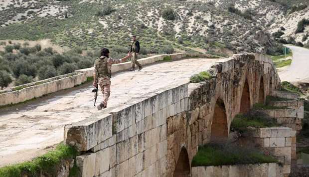 Turkish-backed Syrian opposition fighters walk on the Roman bridge in the archaeological site of Cyrrhus, or Nabi Huri, northeast of the Syrian city of Afrin, after taking control of it from the Kurdish People's Protection Units (YPG) on Friday.