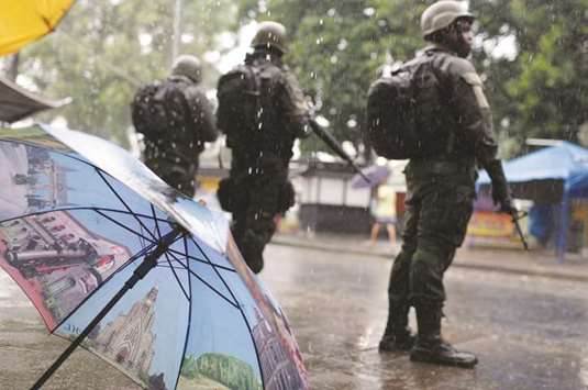 Armed forces members patrol during an operation against drug dealers in Vila Kennedy slum in Rio de Janeiro on Friday. The latest wave of violence in this crime-prone city reflects the economic malaise that has come with recession and hinders its recovery.