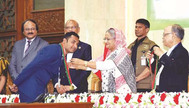 Prime Minister Sheikh Hasina presenting gold medal to a student at an event in Dhaka yesterday.