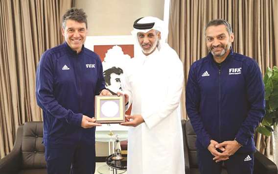 QFA President Sheikh Hamad bin Khalifa bin Ahmed al-Thani presents a memento to Massimo Busacca, Director of the FIFA Refereeing Department, at the QFA headquarters in Al Bidda Tower on Thursday. At right is Hani Ballan, Vice Chairman of FIFA Refereesu2019 Committee.