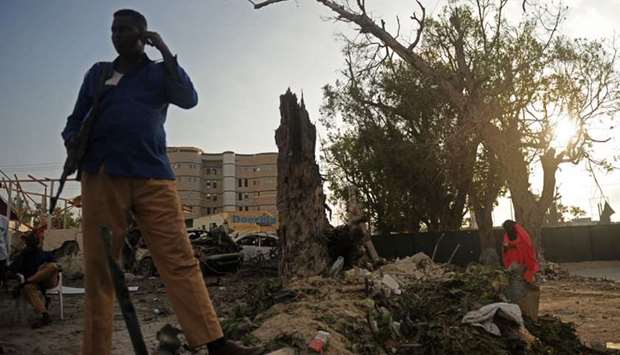 Somali security officer stands guard at the scene of a suicide car explosion in front of Doorbin hotel Saturday in Mogadishu.