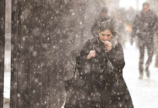People make their way through a snow flurry in London yesterday.