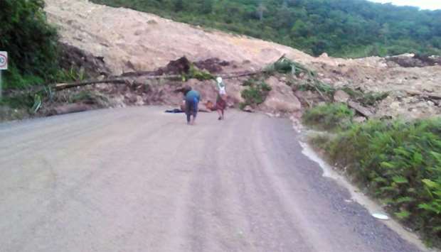 Locals inspecting a landslide and damage to a road located near the township of Tabubil after an ear