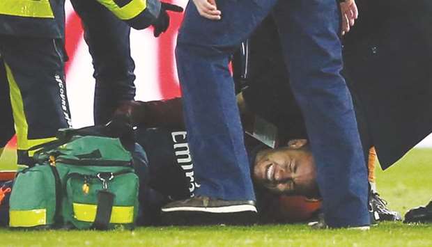 Neymar grimaces in pain as he receives treatment on the field on Sunday night.
